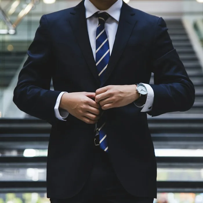 Executive in a suit standing by a window