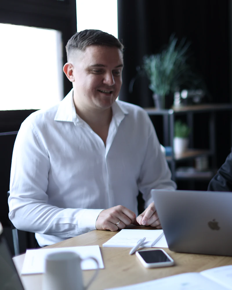 Two colleagues reviewing work together on a laptop