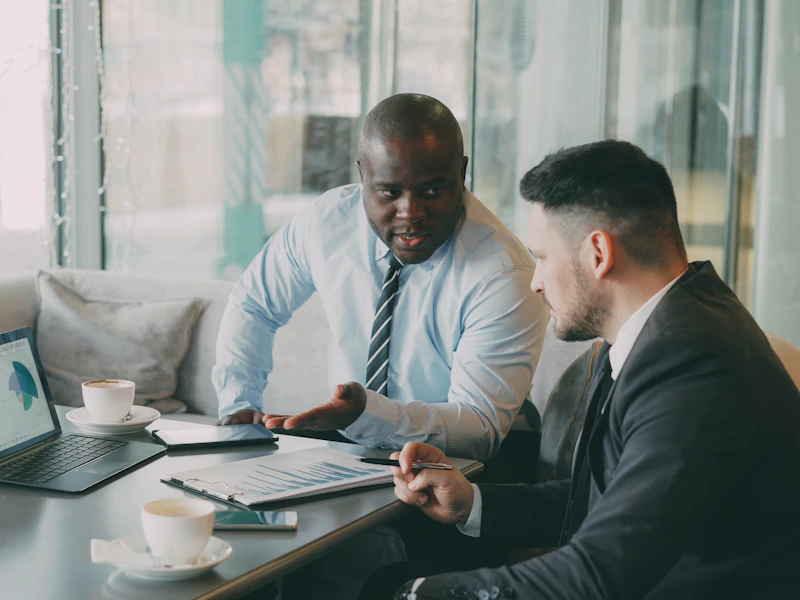 Two executives reviewing charts on a laptop